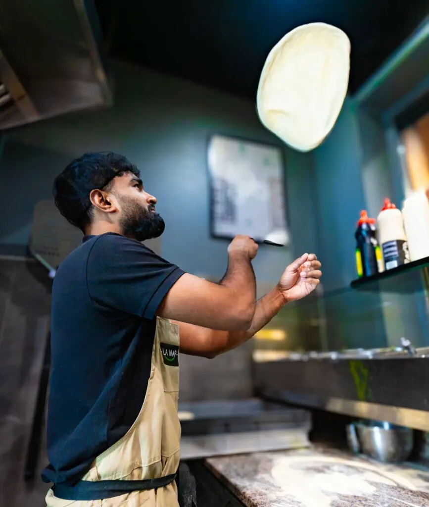 Le pizzaiolo fait tourner la pâte